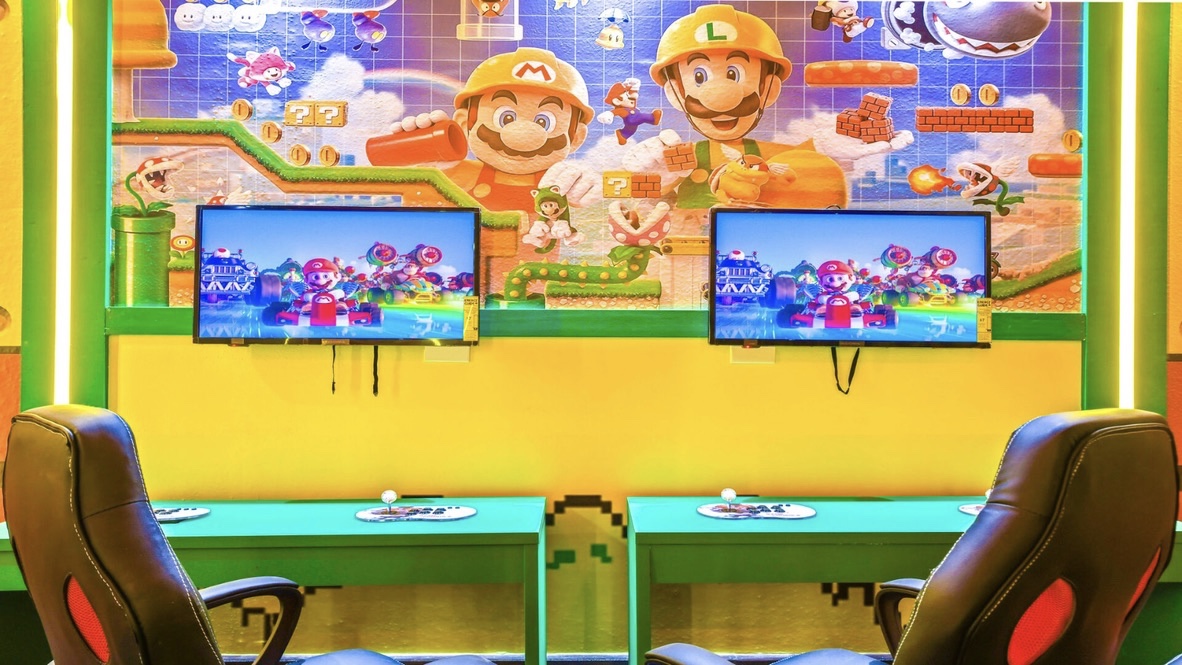 Super Mario gaming station with dual monitors and racing chairs